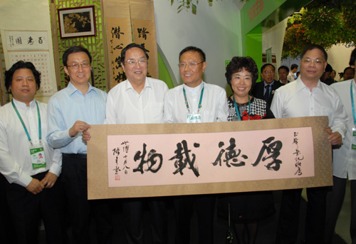 圖為上海殘疾人才藝展示周參展藝術家鄭階平向俞正聲書記贈送作品